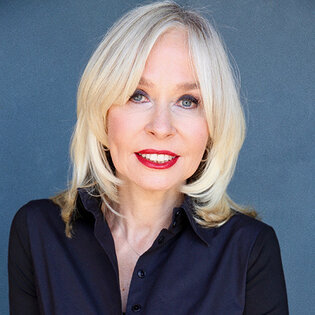 Smiling woman with blond hair and navy blue shirt.